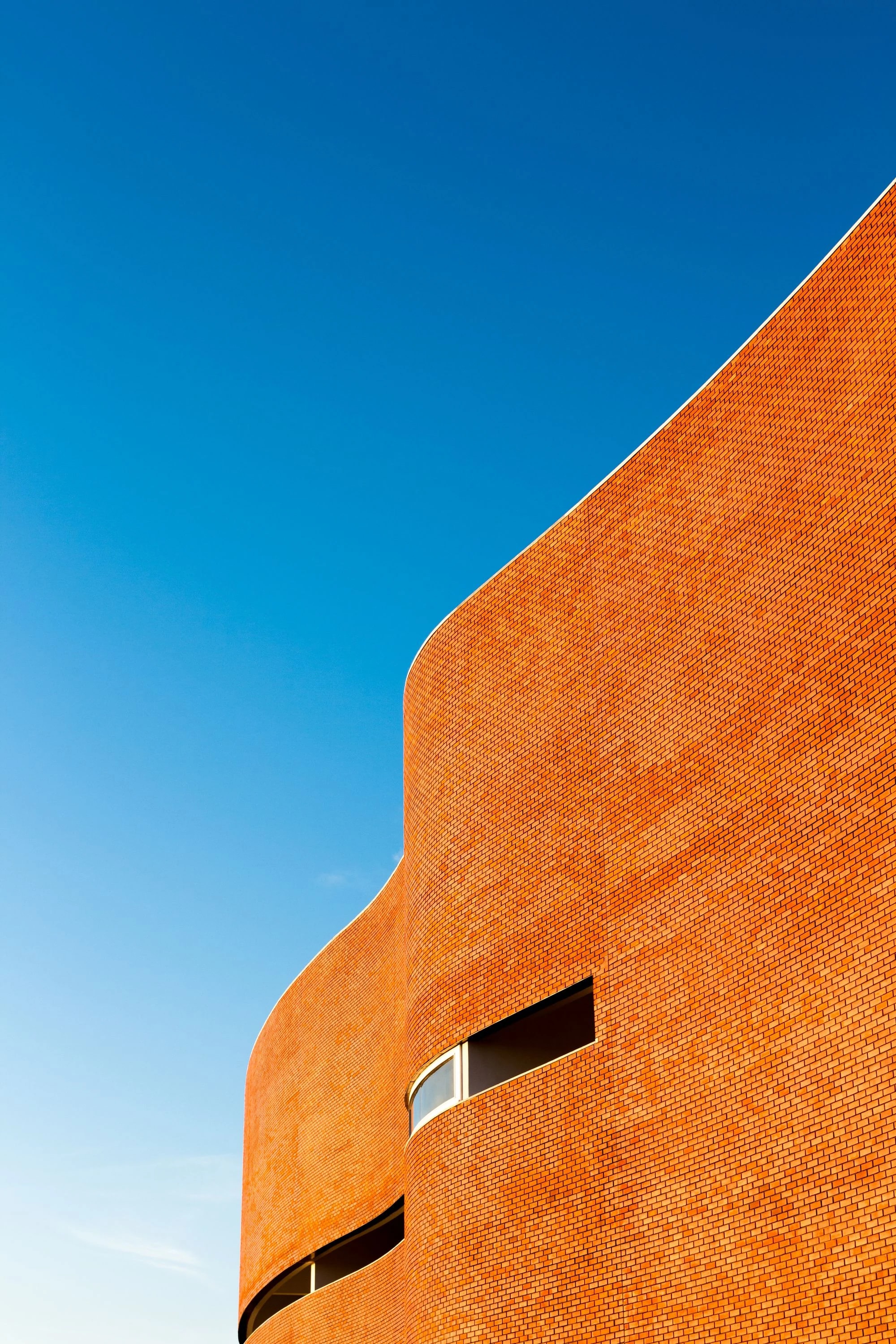 A sculptural brick facade in warm sunlight
